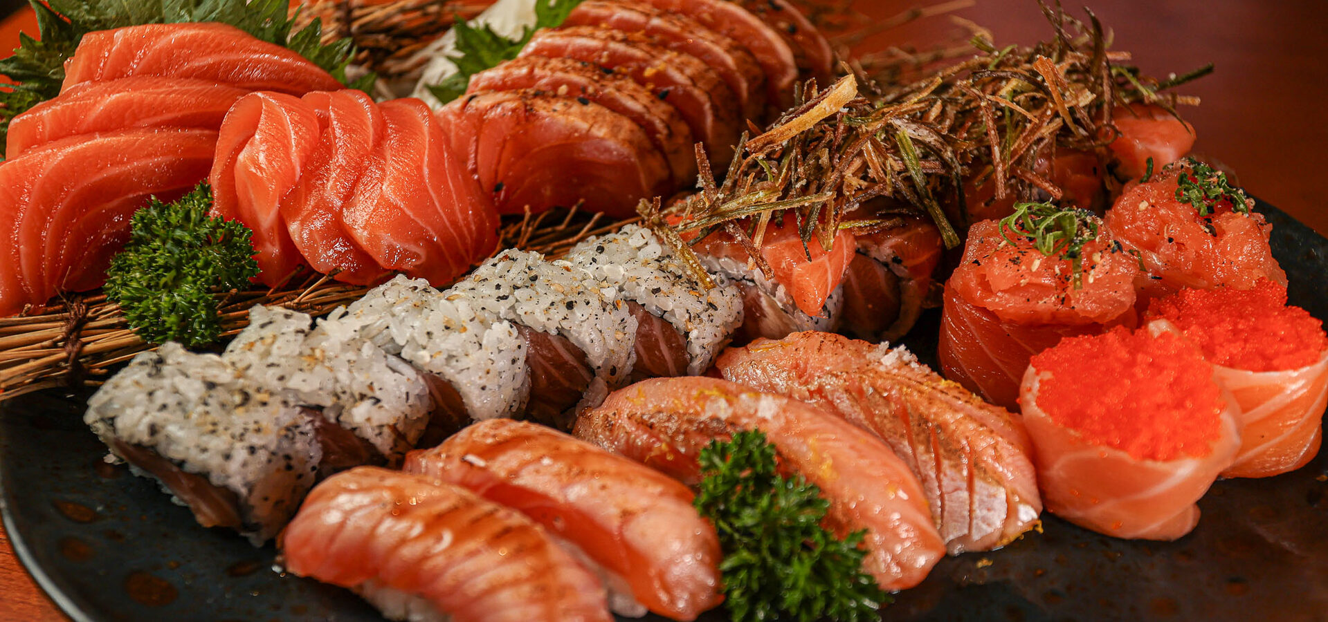 Travessa com sashimis, uramakis e nigiris de salmão