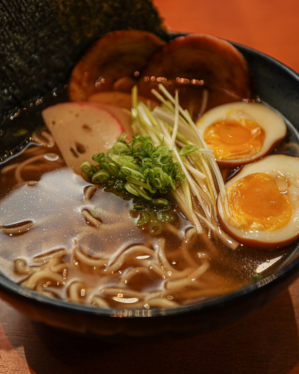 Tigela de ramen com ovo marinado, naruto e cebolinha